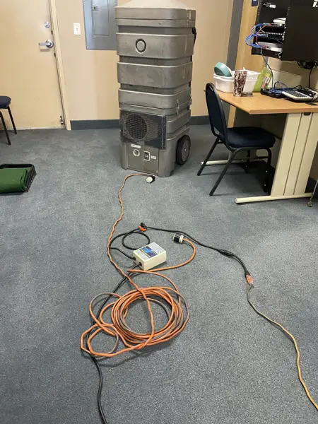 Portable duct-cleaning vacuum unit set up in an office
