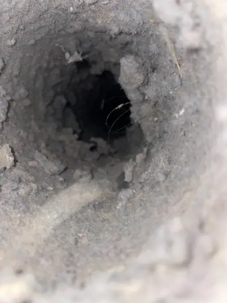 Dirty round air duct interior lined with dust